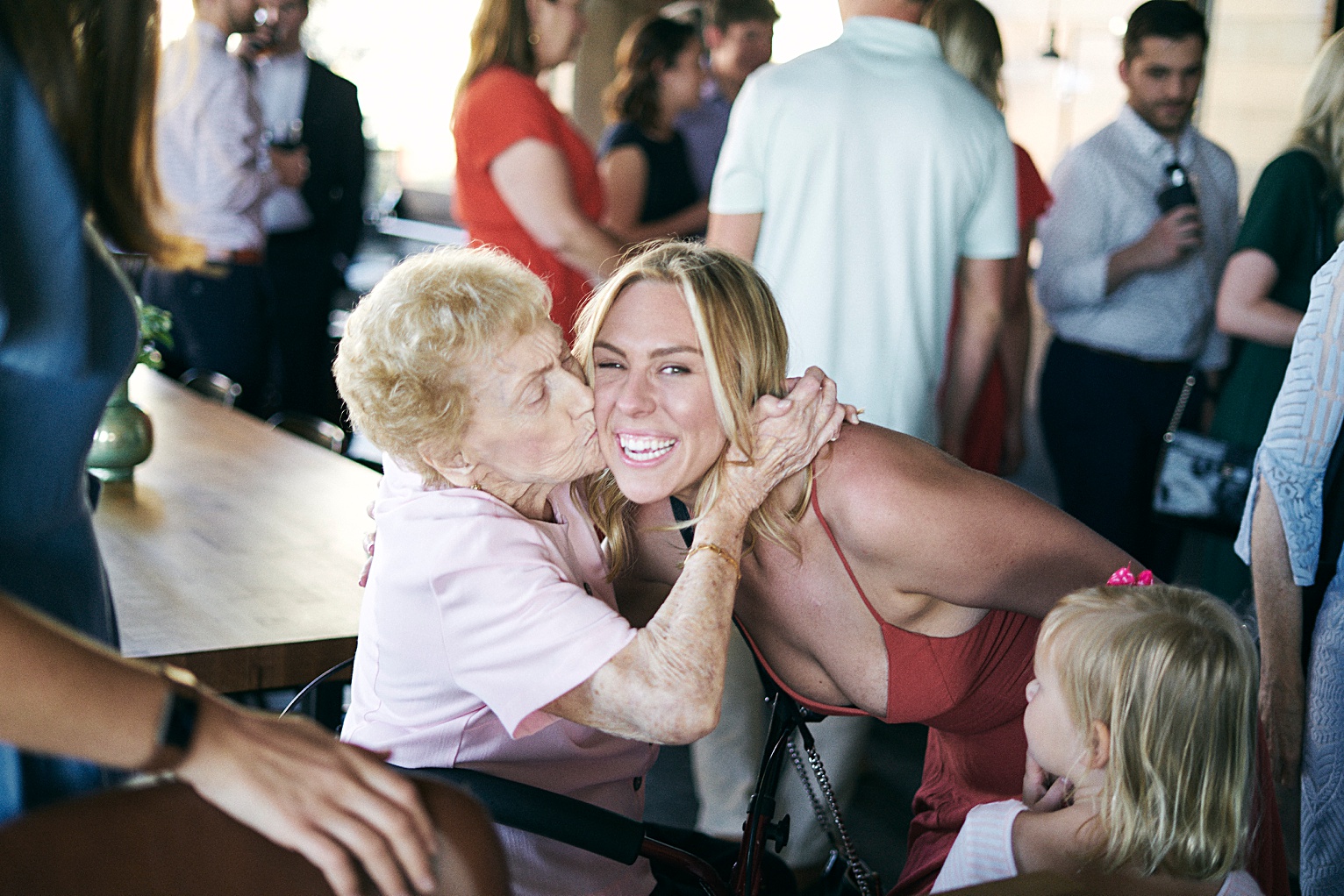 bridesmaid kissing grandmother at rehearsal dinner